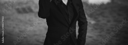 Фотография handsome man in a black suit outdoor