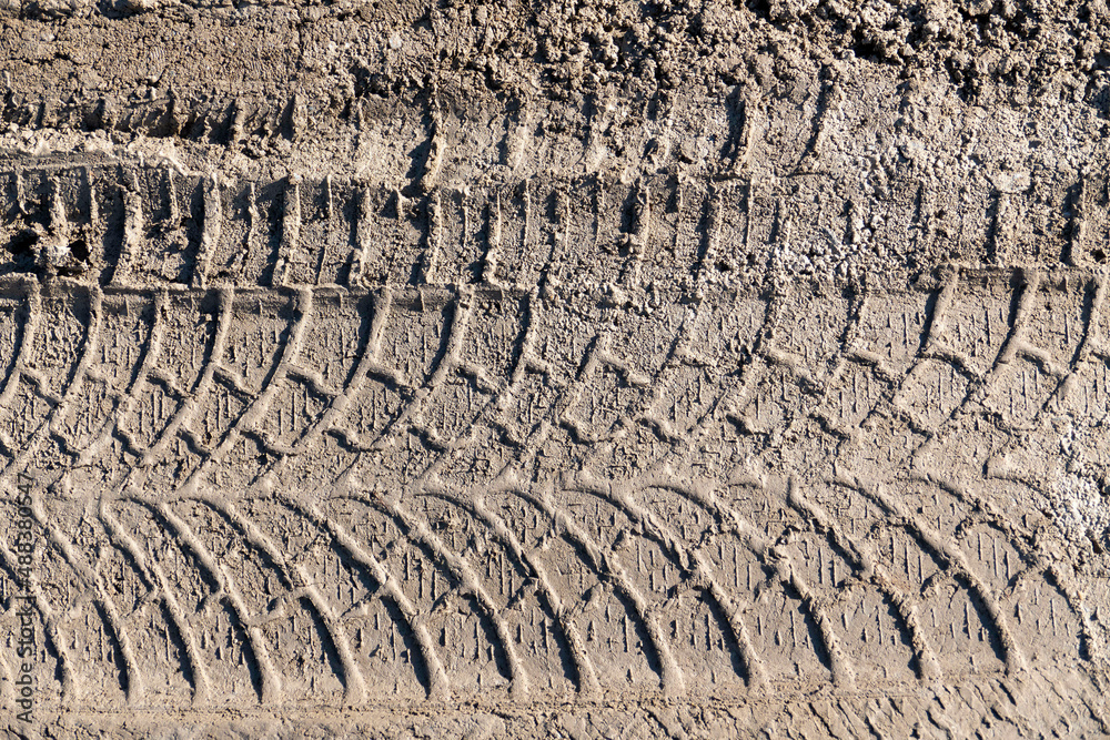 automobile tire marks on mud, tire marks on mud, tire tread marks on mud, ภาพถ่ายสต็อก Adobe Stock