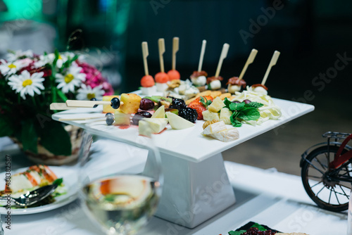 Fotobehang A white ceramic coaster with hors d'oeuvres on the wedding table