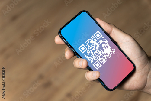 Hand holding a phone with qr code