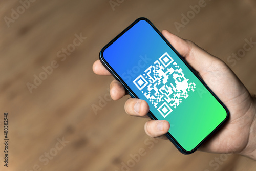 Hand holding a phone with qr code