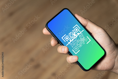 Hand holding a phone with qr code