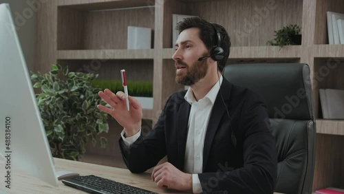 Representive practitioner leads online training wearing a suit and headset, with positive vibes and active gestures and explanations photo