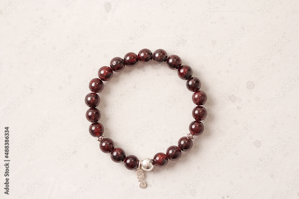 Garnet bracelet. Bracelet made of stones on hand from natural stone Garnet. Bracelet made of natural stones. Handmade jewelry. Handmade bracelets on light modern background. Love Garnet bracelet. Bracelet made of stones on hand from natural stone Garnet. Bracelet made of natural stones. Handmade jewelry. Handmade bracelets on light modern background. Love