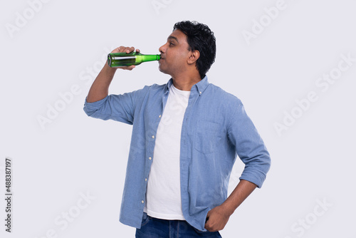 Indian Man Drinking Beer from Glass Beer Bottle. Indian Man with Drink in Hands Isolated