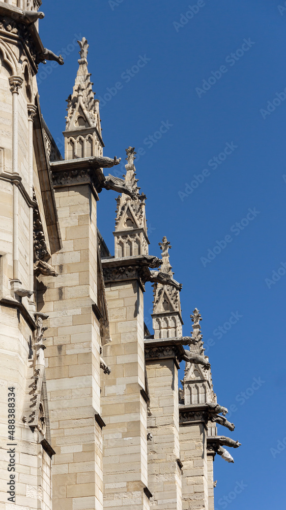 Architectural fragments and gargoyle (chimera) on the facade of Gothic style Holy Chapel (Sainte-Chapelle). Old royal chapel in Paris, France.