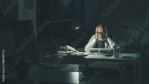Stressed business executive working overtime photo