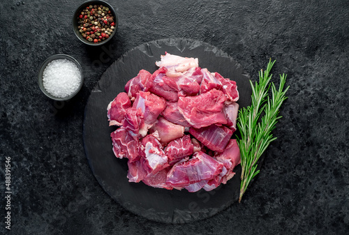 sliced ​​pieces of beef with spices on a stone background