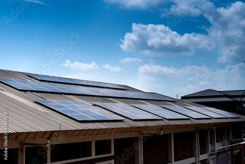 Solar cell panels on the roof with cloudy blue sky background. renewable energy concept and green energy © K.Pornsatid