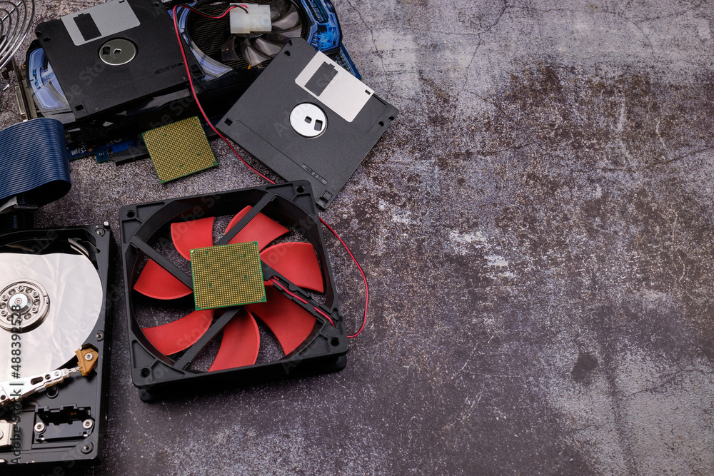 Obraz premium Composition of various computer components on a dark background similar to cement, different computer components such as hard drives, disk drives, graphic controller, micro chips, fans and heat sinks.