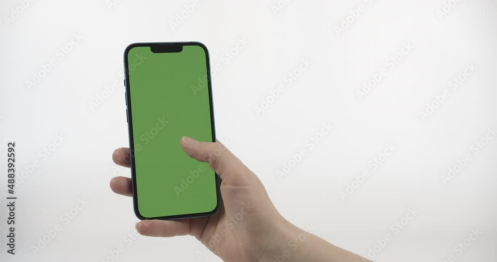 Woman Holding Smartphone With Green Screen, Scrolling Up and Tap Screen. Smartphone with Green Screen in Vertical Position on White Background Woman Holding Smartphone With Green Screen, Scrolling Up and Tap Screen. Smartphone with Green Screen in Vertical Position on White Background