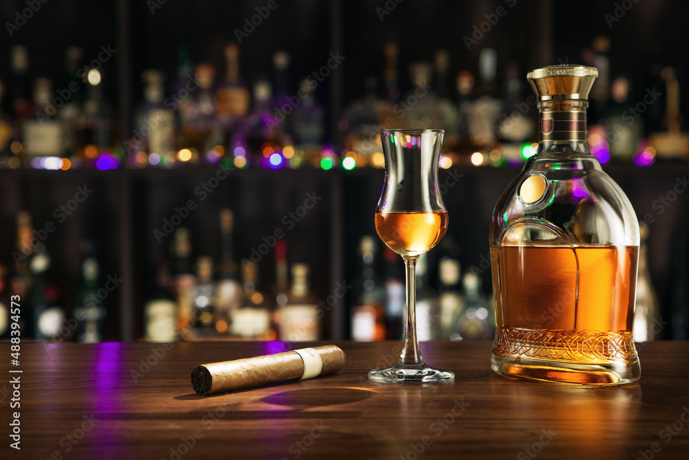 close up view of cigar, bottle of rum and a glass aside on color back.  - obrazy, fototapety, plakaty 