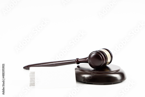 Judge, wooden gavel on the brown wooden background with white, blank business cards. Mockup with copy space