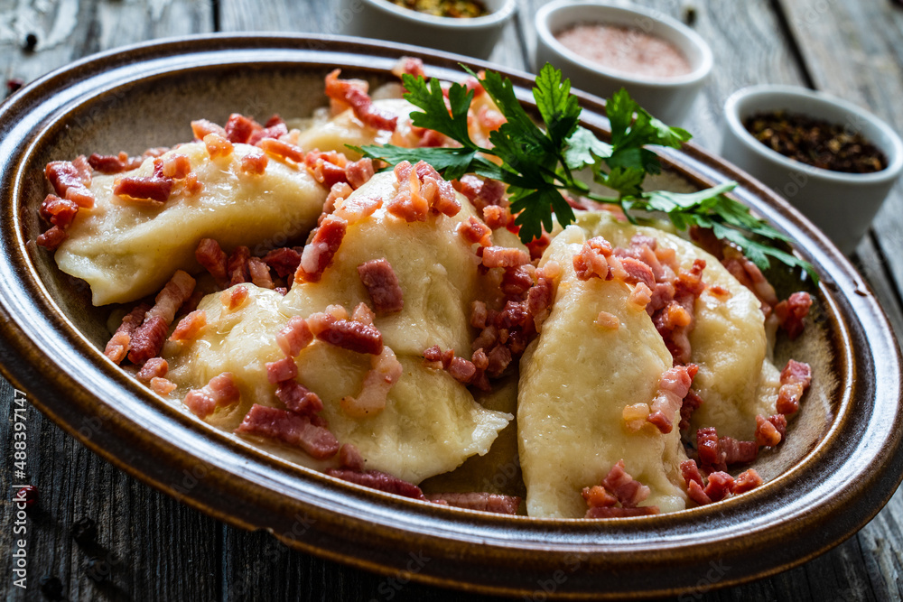 Dumplings - cheese noodles with onion and bacon on wooden background
Dumplings - cheese noodles with onion and bacon on wooden background