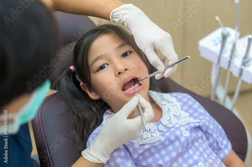 A little cute girl having teeth examined by dentist in dental clinic  teeth check-up and Healthy teeth concept