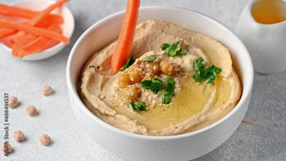 Eating hummus with carrot. hummus with sesame and olive oil. Healthy vegan food. Vegetarian dish. Mezze chickpeas. Kosher food. Eating hummus with carrot. hummus with sesame and olive oil. Healthy vegan food. Vegetarian dish. Mezze chickpeas. Kosher food.