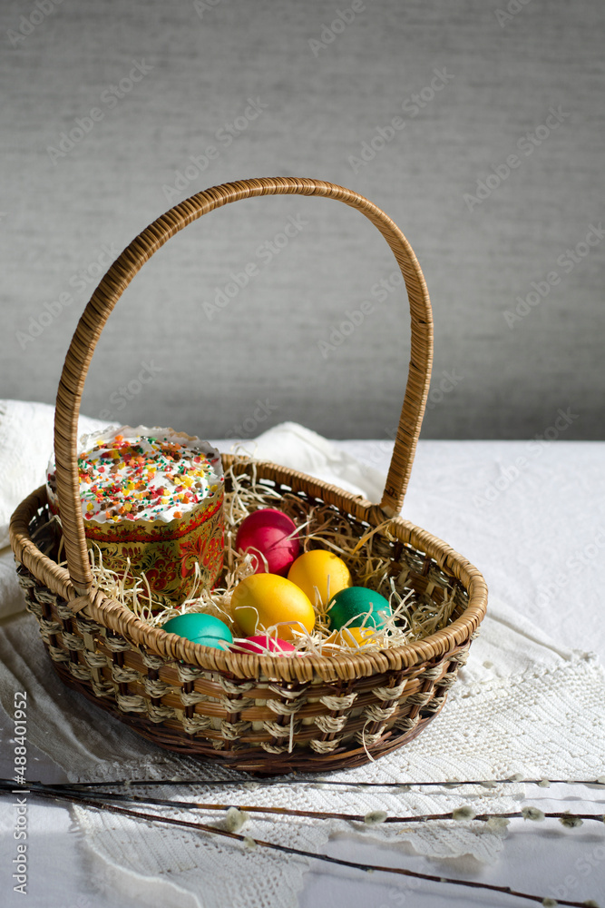 Easter card. Willow branches, a basket with painted eggs and festive Easter cakes.