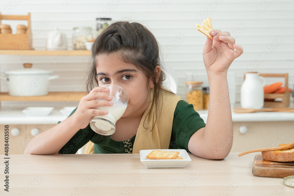 child drinking cup or mug of milk in the domestic kitchen Stock