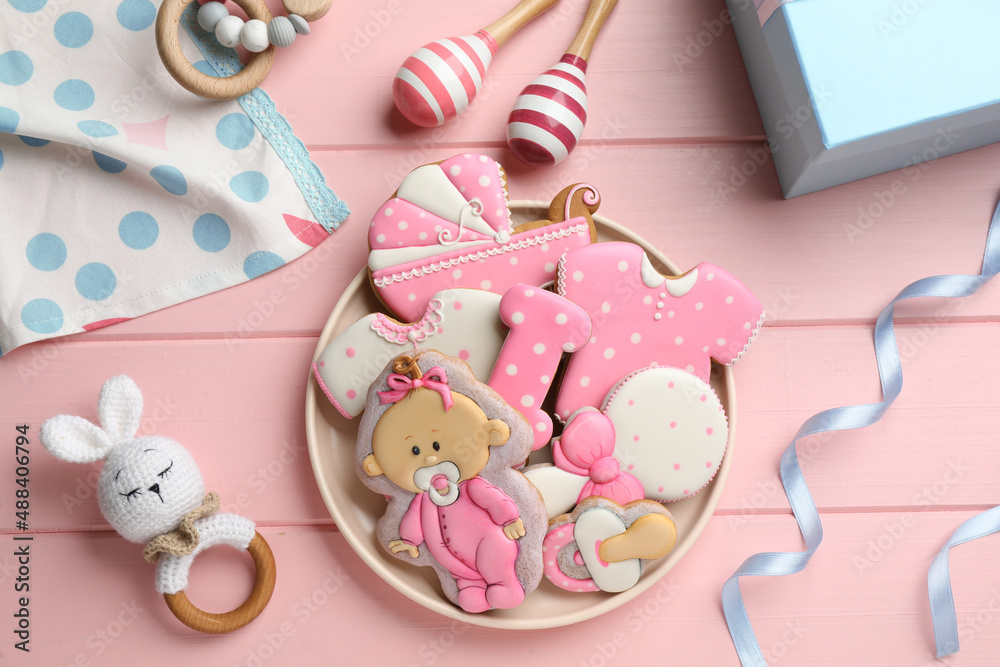 Tasty cookies of different shapes and toys on pink wooden table, flat lay. Baby shower party Tasty cookies of different shapes and toys on pink wooden table, flat lay. Baby shower party