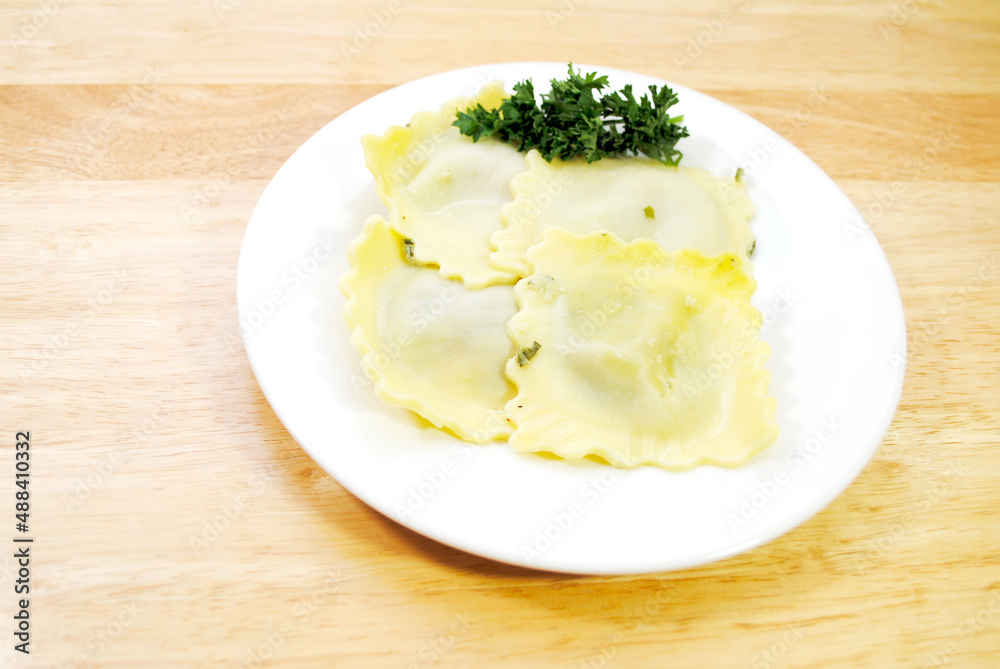 Four Appetizing Large Spinach Raviolis on a White with Parsley Garnish