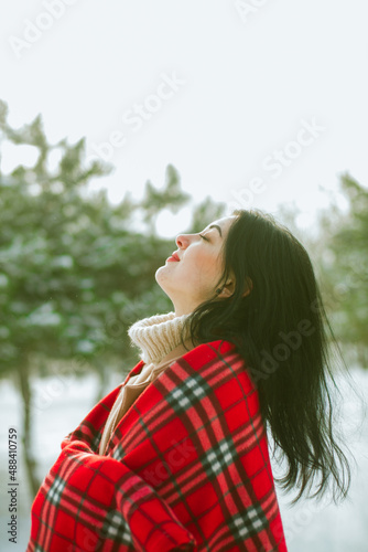 Young cute girl with durk hair in red scarf has fun in snowy weather in winter in the park. Life style  photo