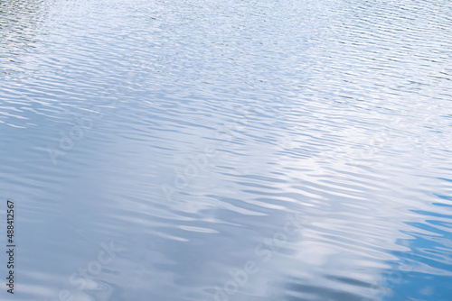 Rippled clean blue river surface with cloudy sky reflection