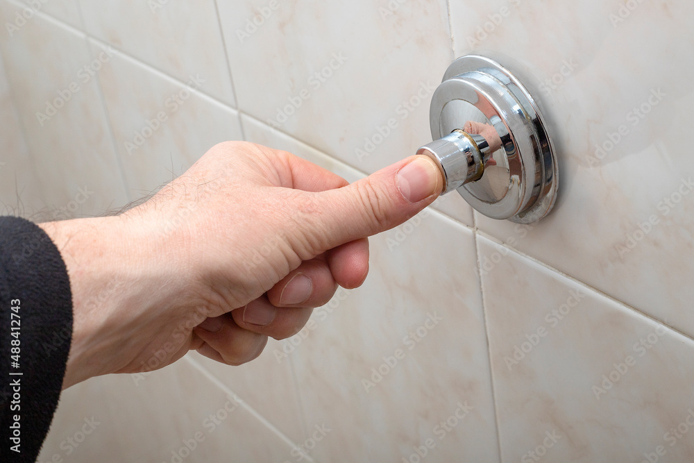 Hand of a man pushing the toilet drain Hand of a man pushing the toilet drain