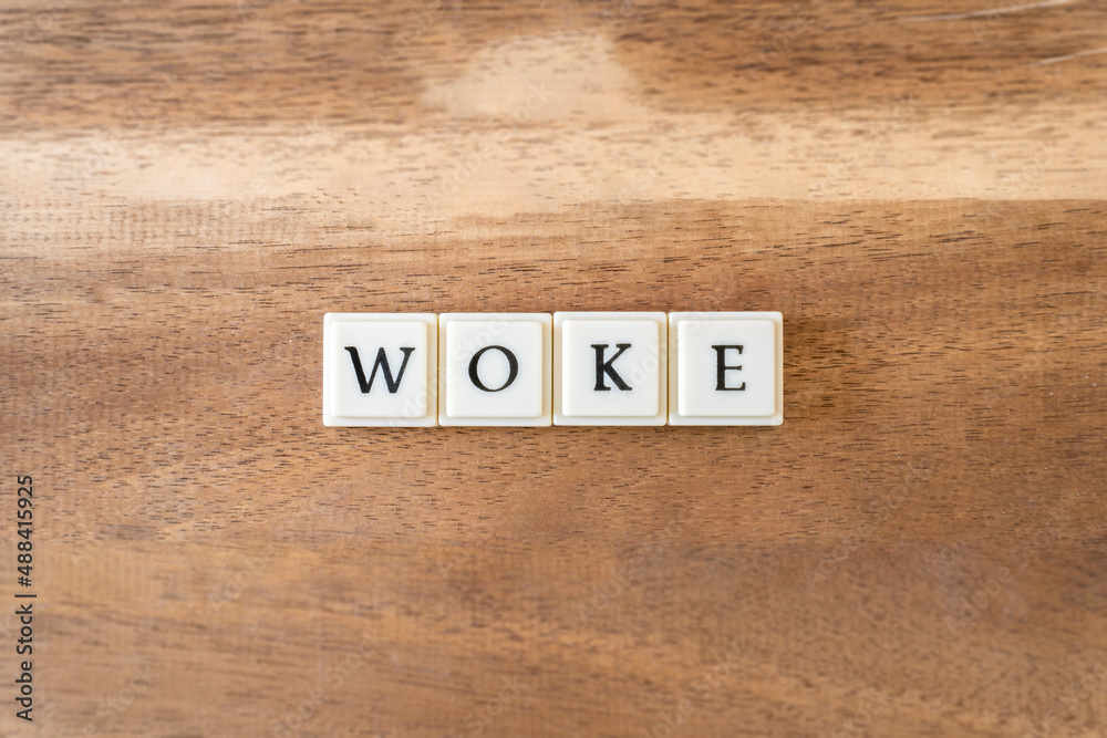 Fototapeta premium The word Woke on a wooden background.