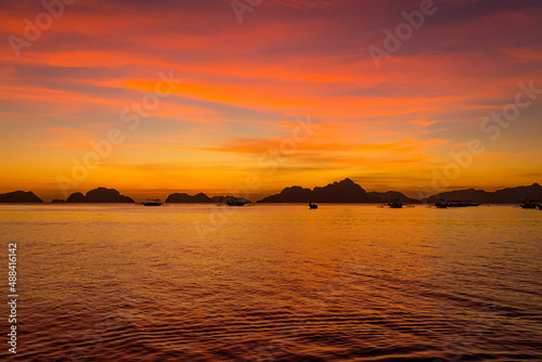 Picturesque tropical sunset. Dramatic evening sky above island. Night sea with mountains silhouettes. Exotic seascape in evening twilight. El Nido lagoon in night dusk. Amazing evening sky on Palawan 