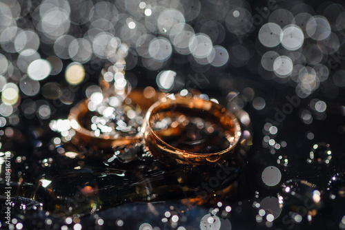 Wedding rings with water droplets The engagement ring set. Beautiful silver background with wedding rings and stars