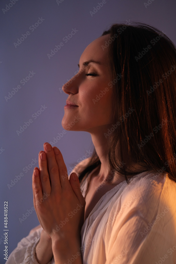 vertical authentic portrait of caucasian praying woman in white blouse with hands on her chest with sunset, mother day, Ramadan vertical authentic portrait of caucasian praying woman in white blouse with hands on her chest with sunset, mother day, Ramadan