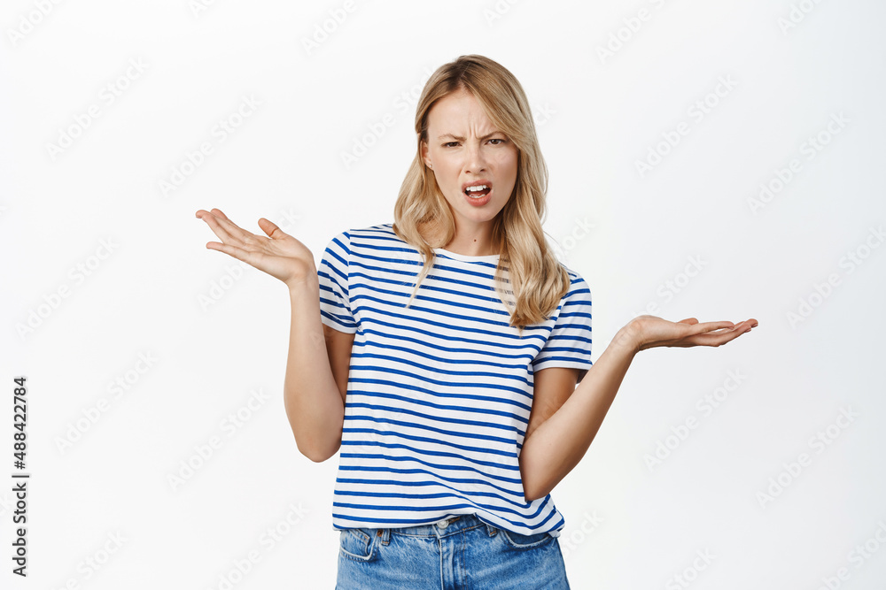 Annoyed and confused sassy woman shrugging, looking perplexed, cant understand whats the problem, why, standing over white background Annoyed and confused sassy woman shrugging, looking perplexed, cant understand whats the problem, why, standing over white background