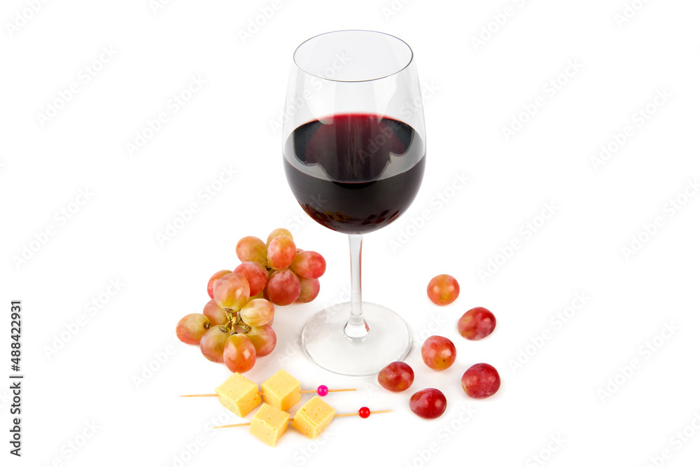 A wineglass of red wine, cheese appetizer and a bunch of grapes isolated on a white.