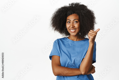 Very good. Smiling pleased adult woman shows thumbs up in approval and nod, satisfied with quality, recommending smth great, standing over white background