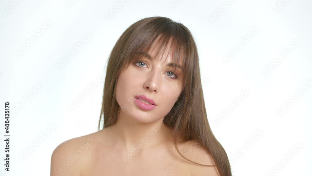 A beautiful woman with bare shoulders touches her face with her fingers. Skin care concept. A beautiful woman with bare shoulders touches her face with her fingers. Skin care concept.