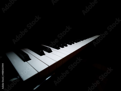 Pianoforte a coda, tastiera bianca illuminata, profilo artistico: foto d'autore photo