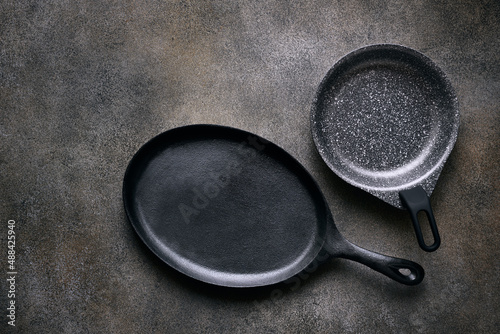 Two empty skillets close up, top view, space for text