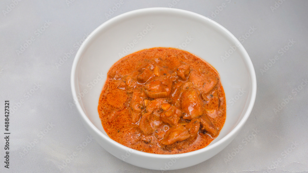 Hungarian paprikash, or meat with paprika and sour cream sauce close up in a bowl on marble background Hungarian paprikash, or meat with paprika and sour cream sauce close up in a bowl on marble background