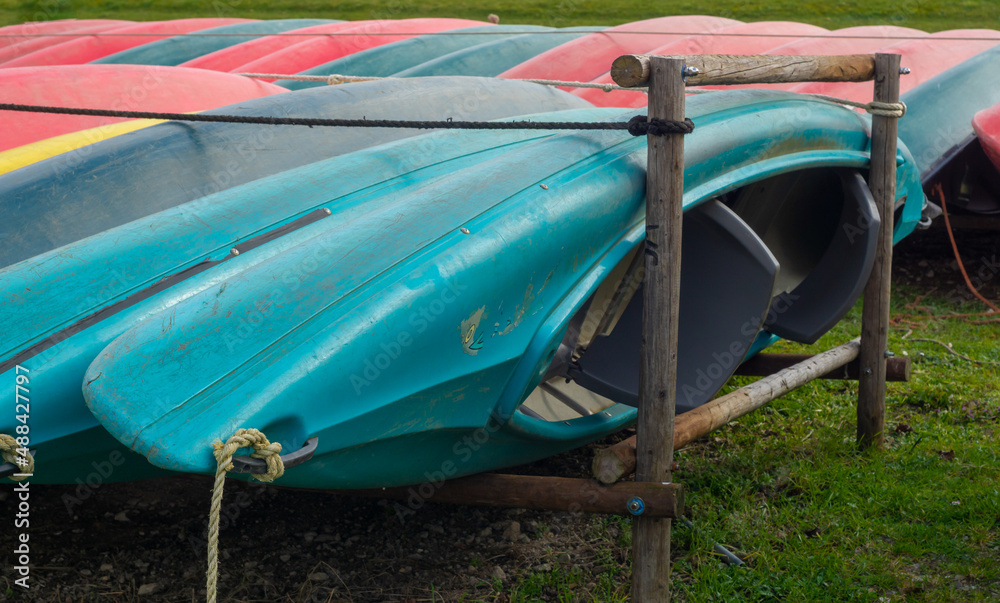 Colorful kayaks hanging on a paddle. Canoe store outdoor in the summer season.