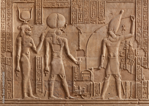 Ancient relief of Kom Ombo temple in Aswan Governorate, Upper Egypt. It was constructed during the Ptolemaic dynasty, 180–47 BC.  Ra God, Hathor Goddess and Pharaoh.