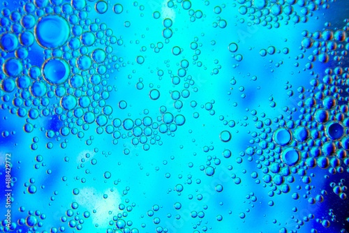 Bubbles in oil in water on blue and white colour abstract background.