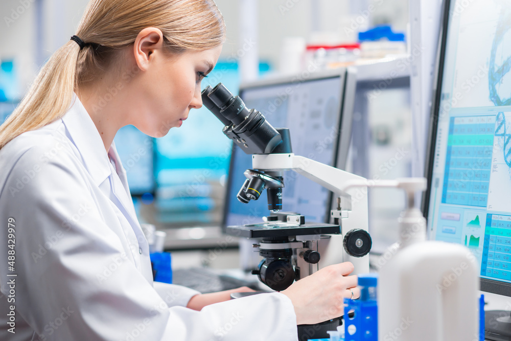 Professional female scientist is working on a vaccine in a modern scientific research laboratory. Genetic engineer workplace. Future technology and science. Professional female scientist is working on a vaccine in a modern scientific research laboratory. Genetic engineer workplace. Future technology and science.