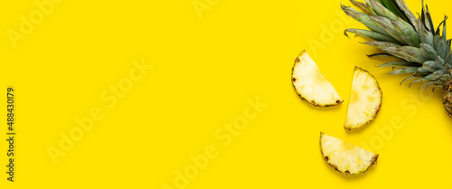 Ripe pineapple slices, pineapple with foliage on a yellow background. Top view, flat lay. Banner