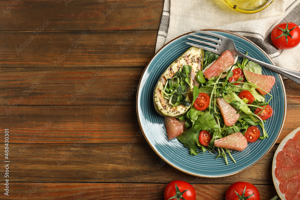Delicious pomelo salad with grilled avocado served on wooden table, flat lay. Space for text Delicious pomelo salad with grilled avocado served on wooden table, flat lay. Space for text