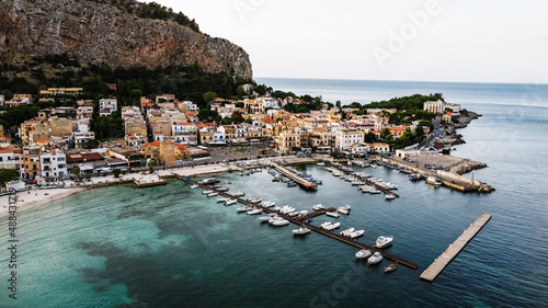 Aerial view of marina with mountain in background. 
Boat mooring drone shot. Port in Sicily. Panoramic landscape of Mondello Beach in Palermo, Sicily.