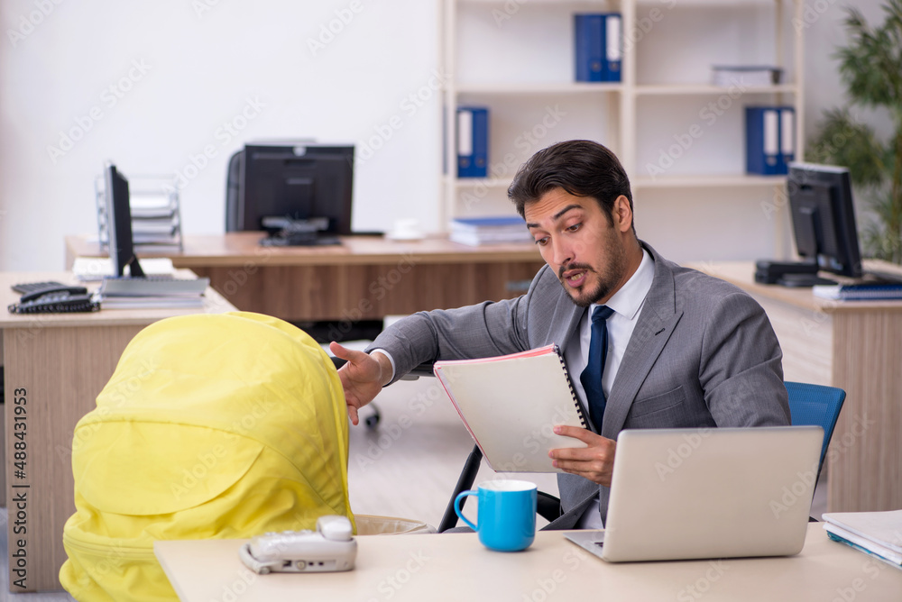Young male employee looking after new born at workplace Young male employee looking after new born at workplace