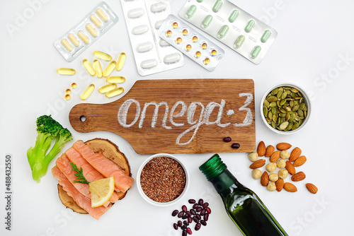 The concept of choosing between proper nutrition and medication. Layout of products with omega-3 and capsules with omega-3 on a white background