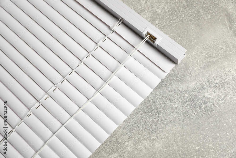 Obraz premium Stylish horizontal window blinds on grey table, top view