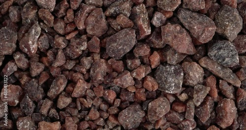 Top view of Himalayan black salt rocks rotating. Kala namak salt. Closeup. Macro.