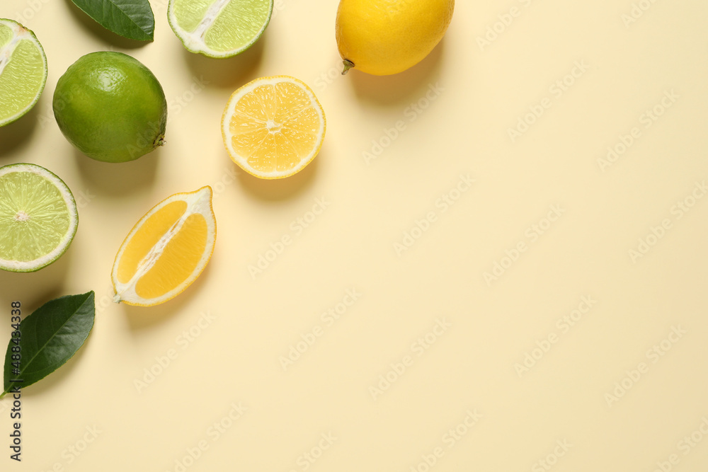 Fresh ripe lemons, limes and green leaves on beige background, flat lay. Space for text Fresh ripe lemons, limes and green leaves on beige background, flat lay. Space for text
